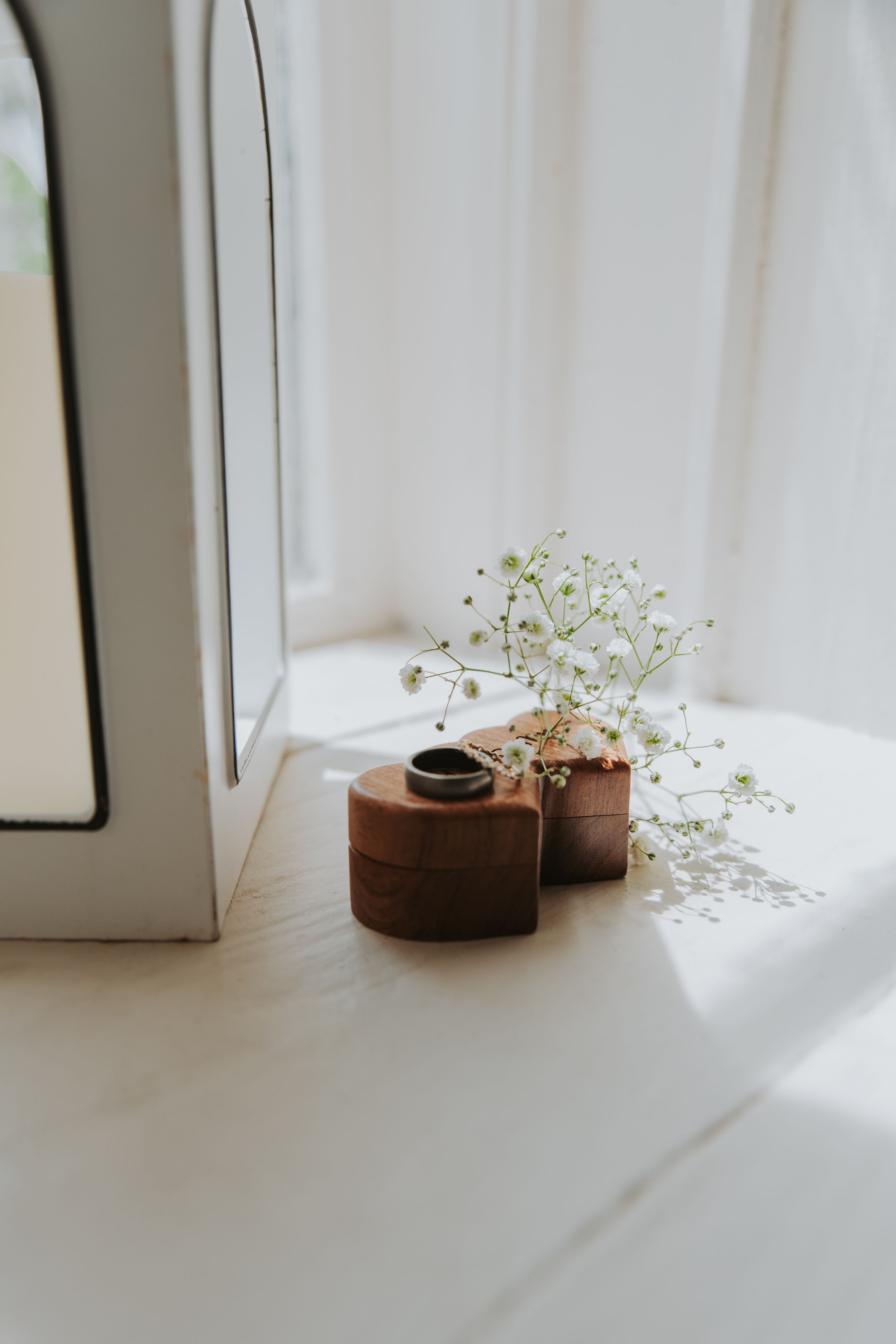 Delicate white baby's breath flowers arranged in small terracotta pots on a white windowsill.