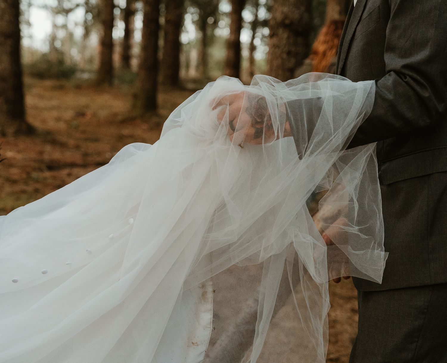 Detail shots of groom holding brides dress train.