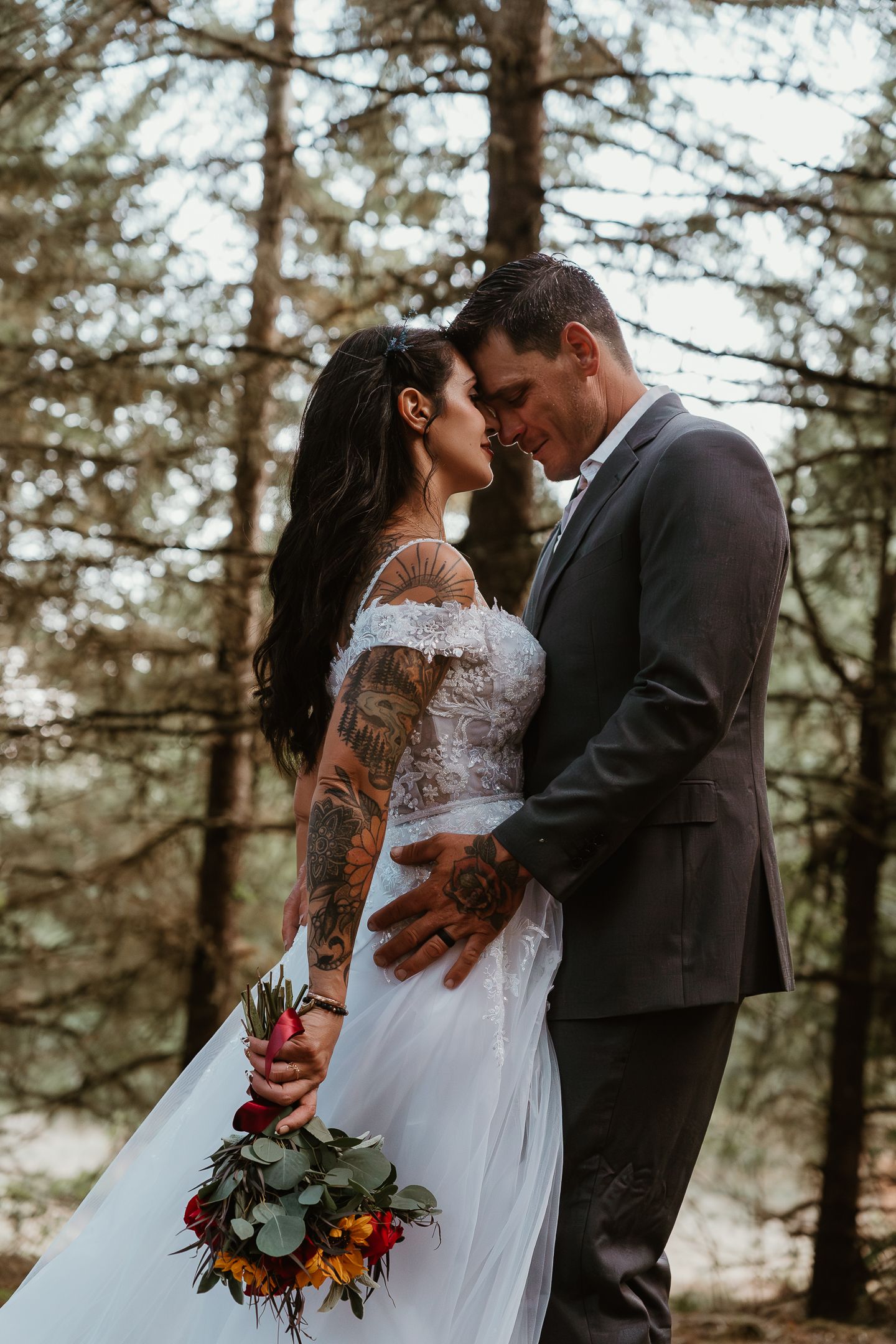 The eloping couple embraced each other, holding a bouquet, with their love captured in a candid moment of joy and intimacy.