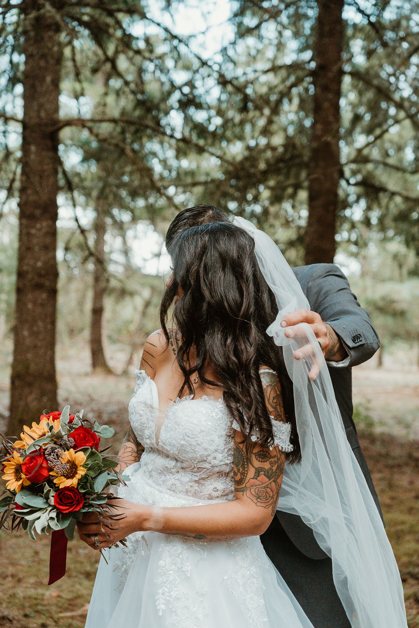 Groom fixing brides veil.