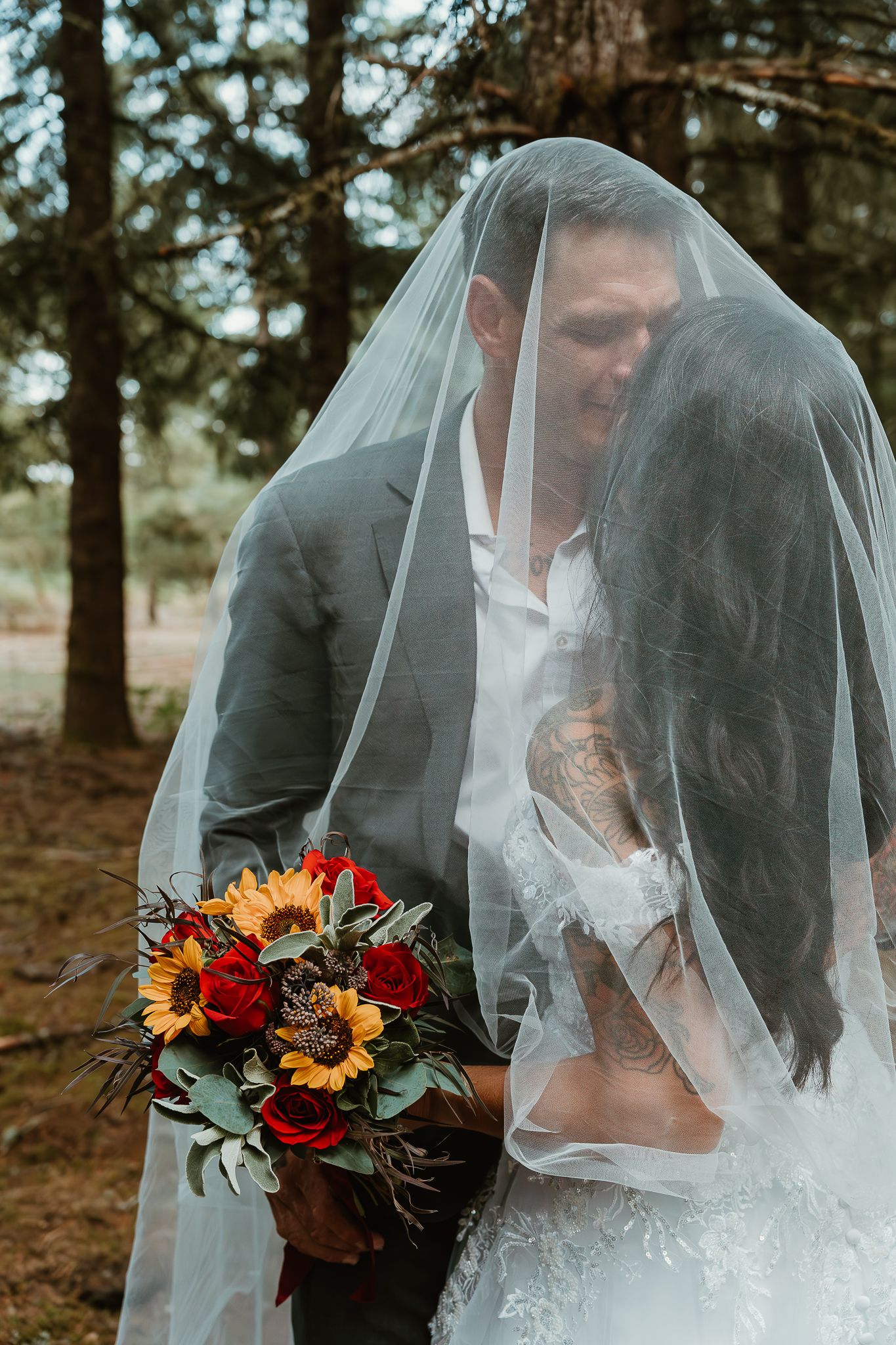 More veil shots showcasing groom kissing bride.
