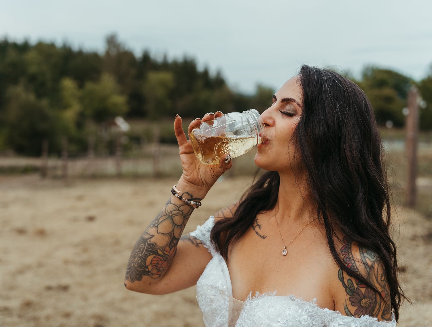 Bride enjoying champagne on farm.