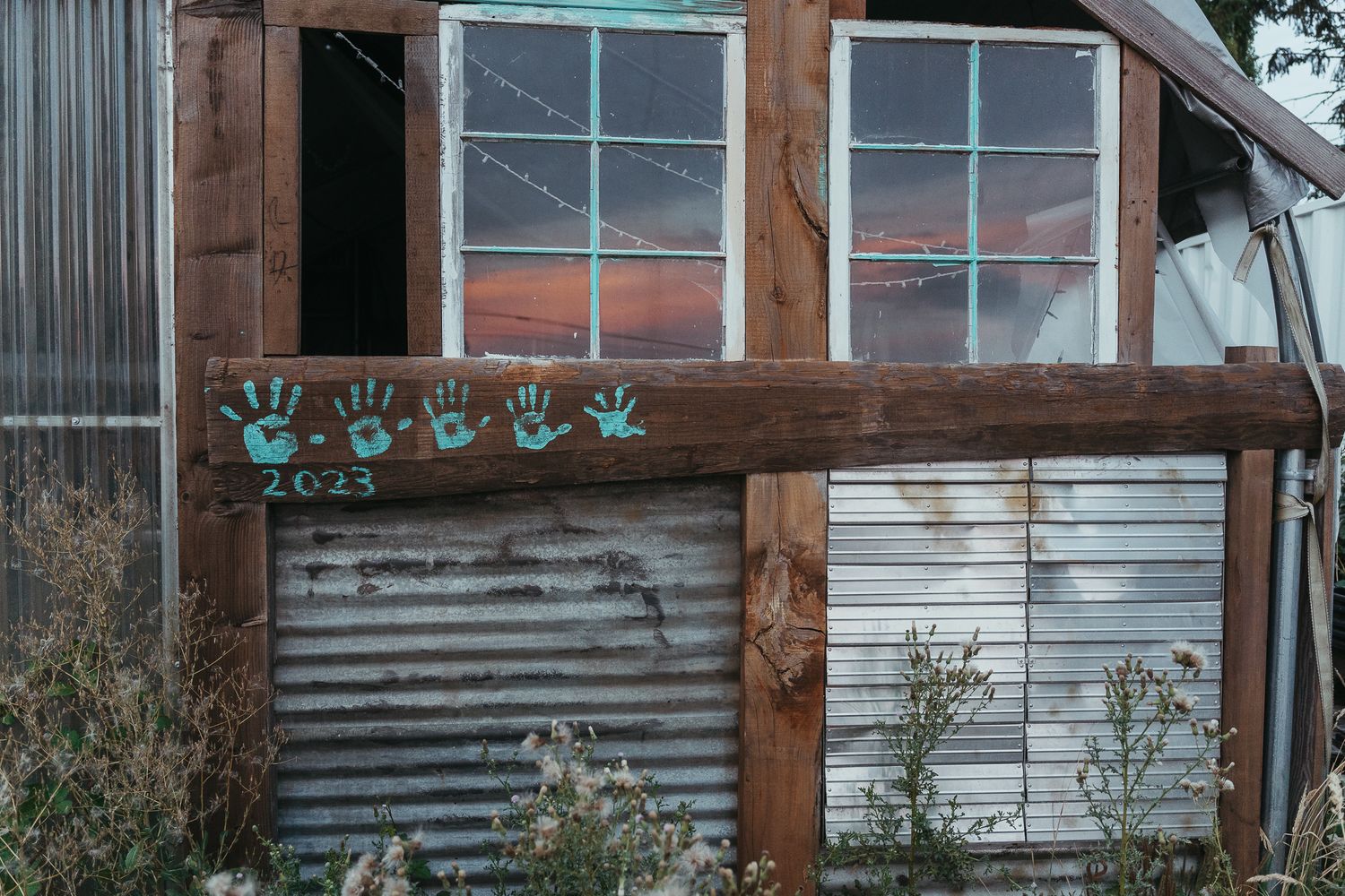 Barn with colorful painted handprints covering its wooden walls, a vibrant display of creativity, community, and shared memories