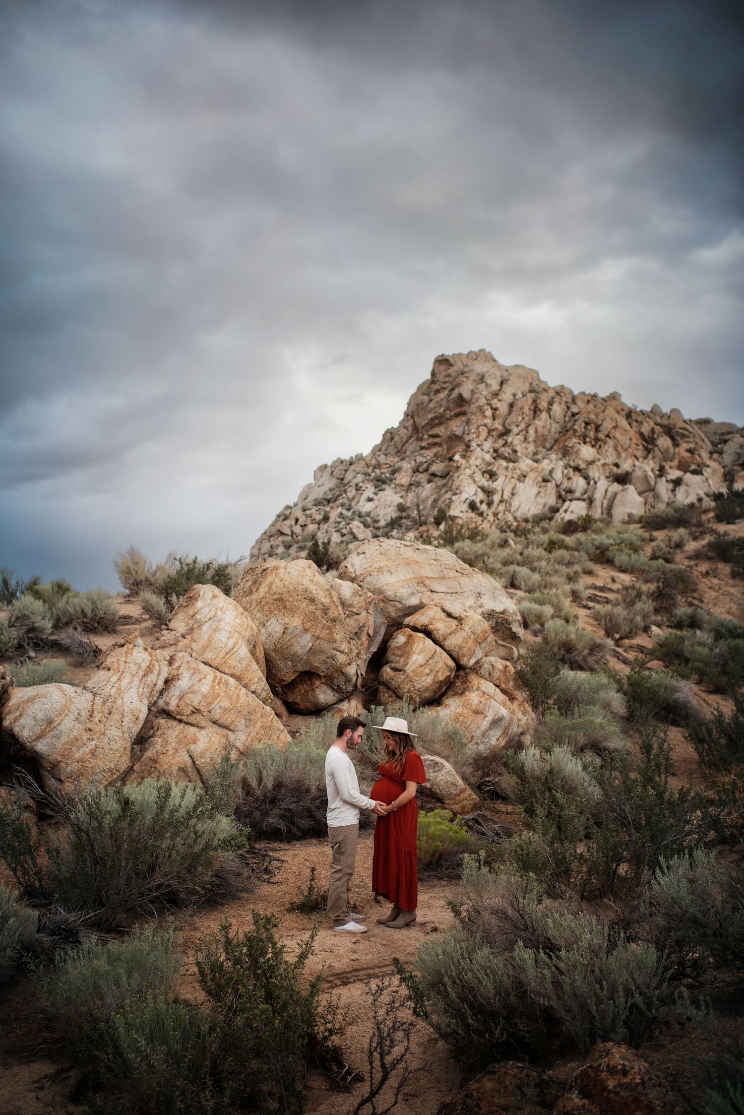 Lake Tahoe maternity photography – couple in desert landscape with dramatic sky, captured by Lake Tahoe photographer.
