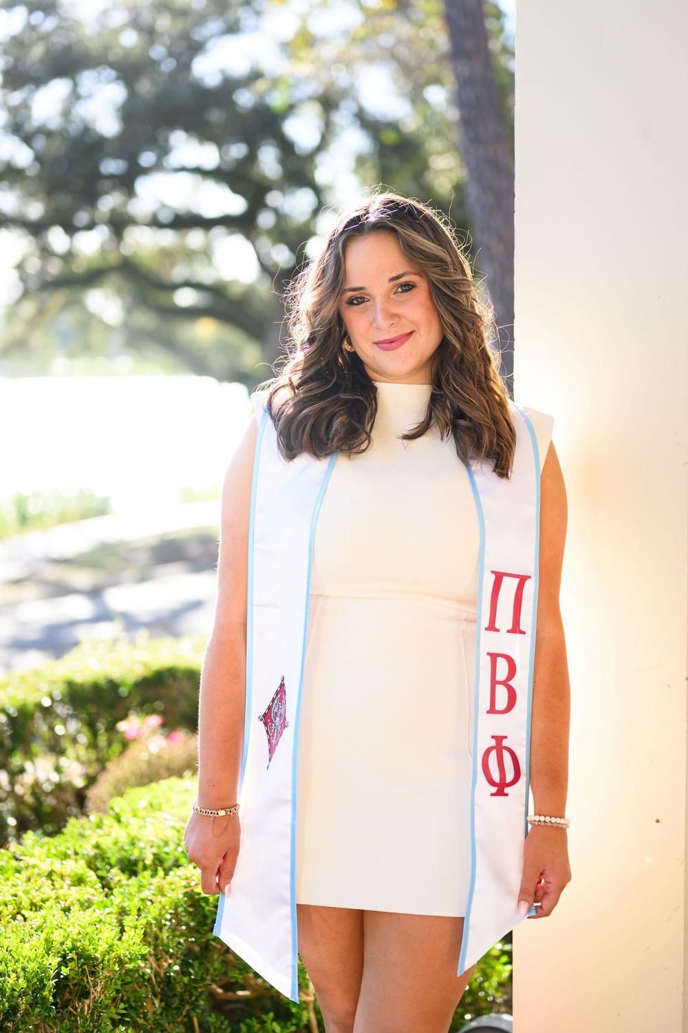 Collage of graduation photos showing white stole with Greek letters against sunny outdoor background.