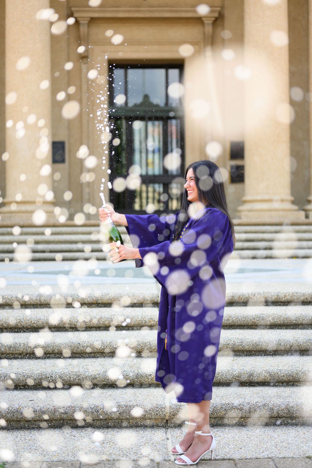 A person in a purple dress stands on snowy steps while holding a sparkler creating a dreamy winter atmosphere.