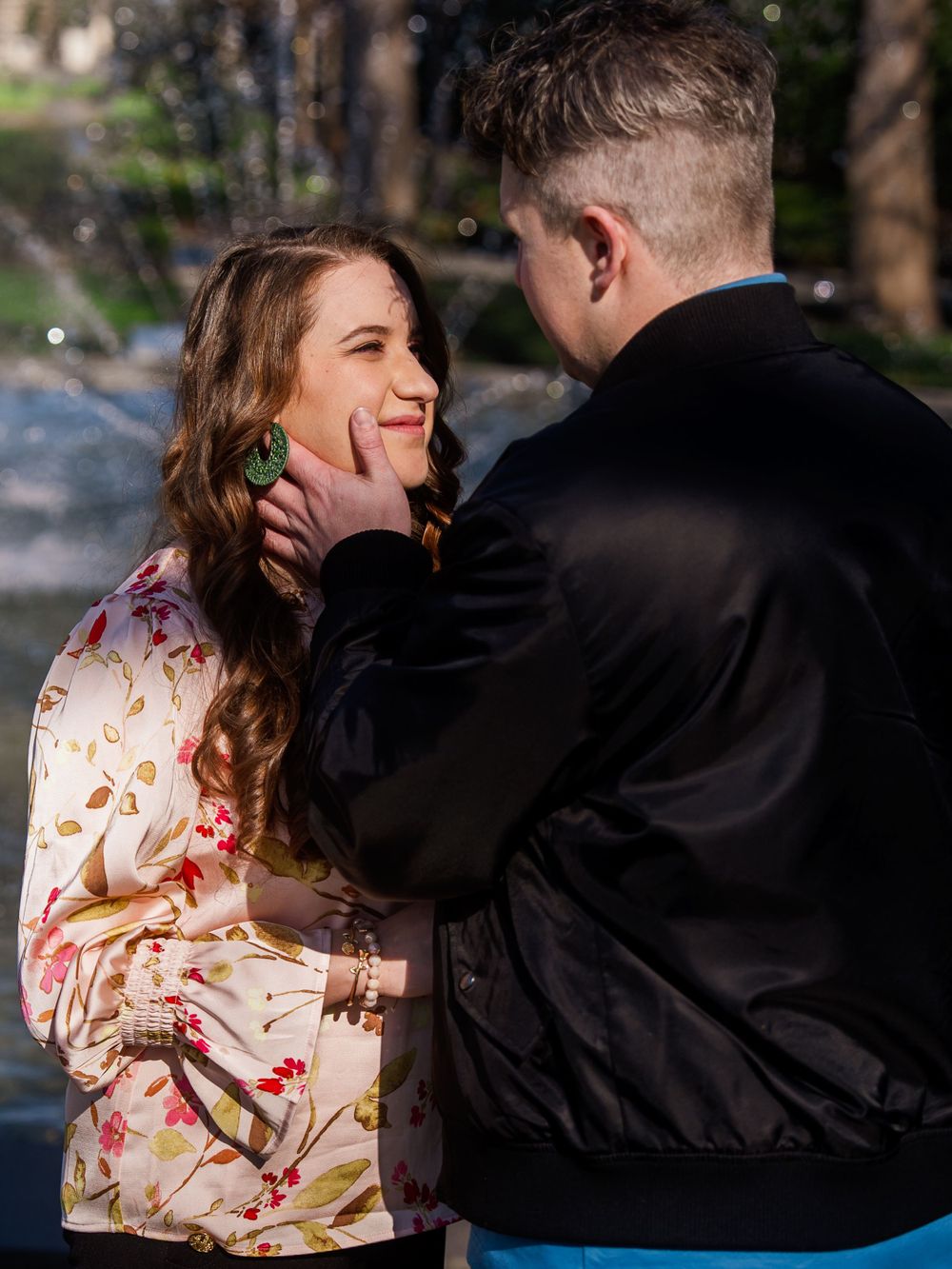 A tender moment captured between a couple, with one wearing a floral dress and the other in dark clothing.