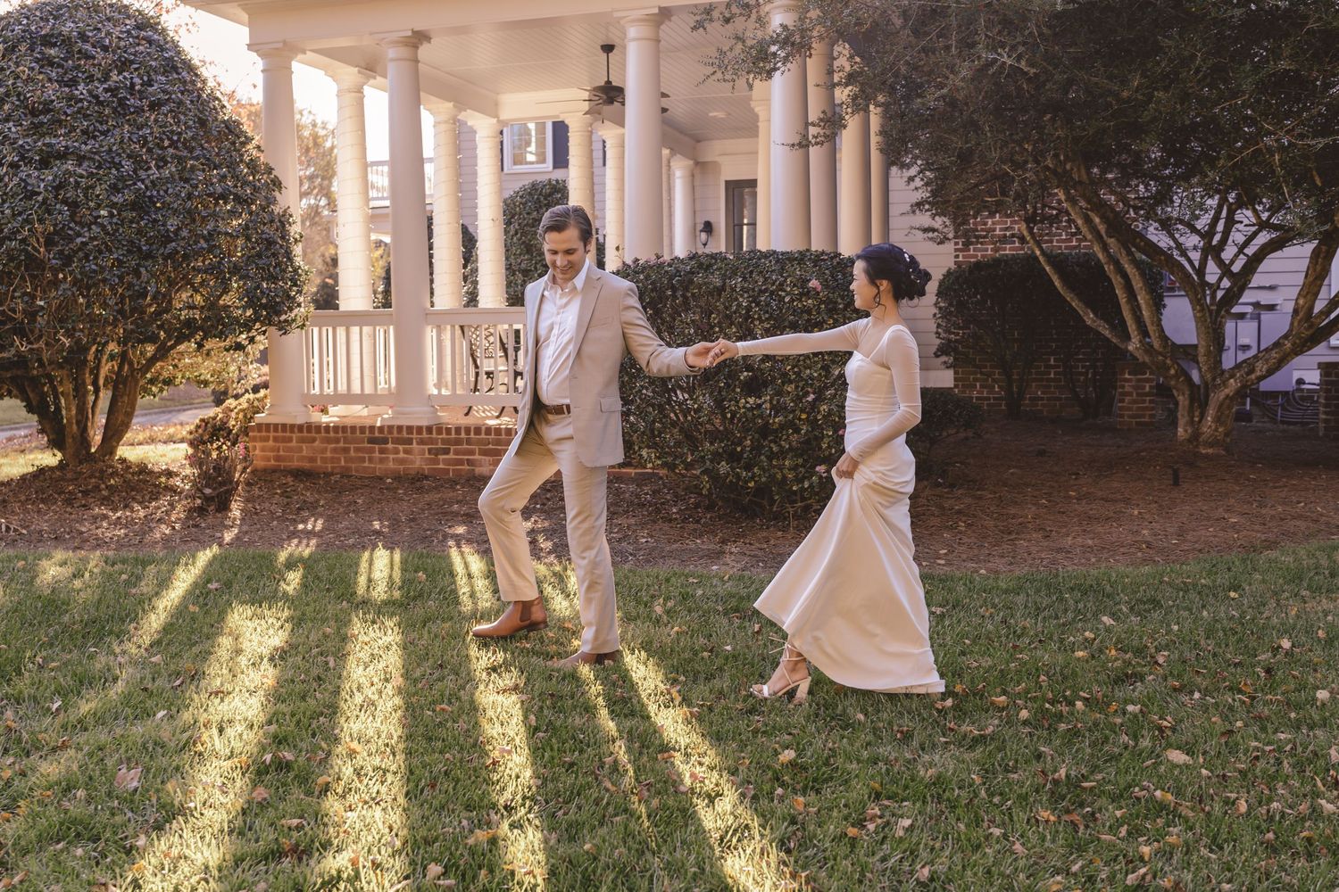 Bride and groom walking through the sunlight at a backyard wedding in Charlotte, NC