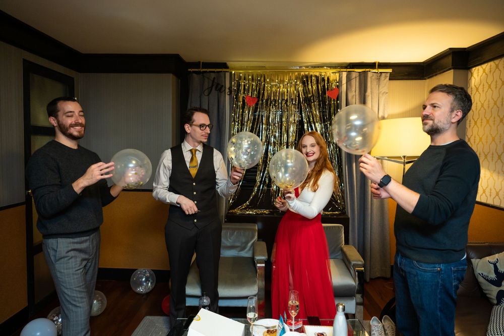 People gathered in a room celebrating with balloons and decorations at a festive party.