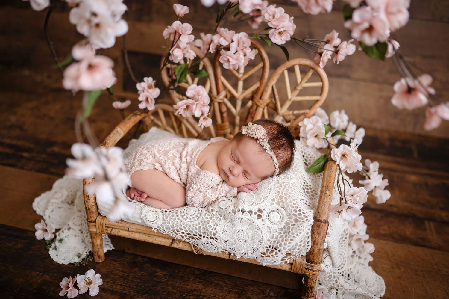 Nouveau-né fille en studio , couché sur un magnifique lit de bois. Style vintage et boho