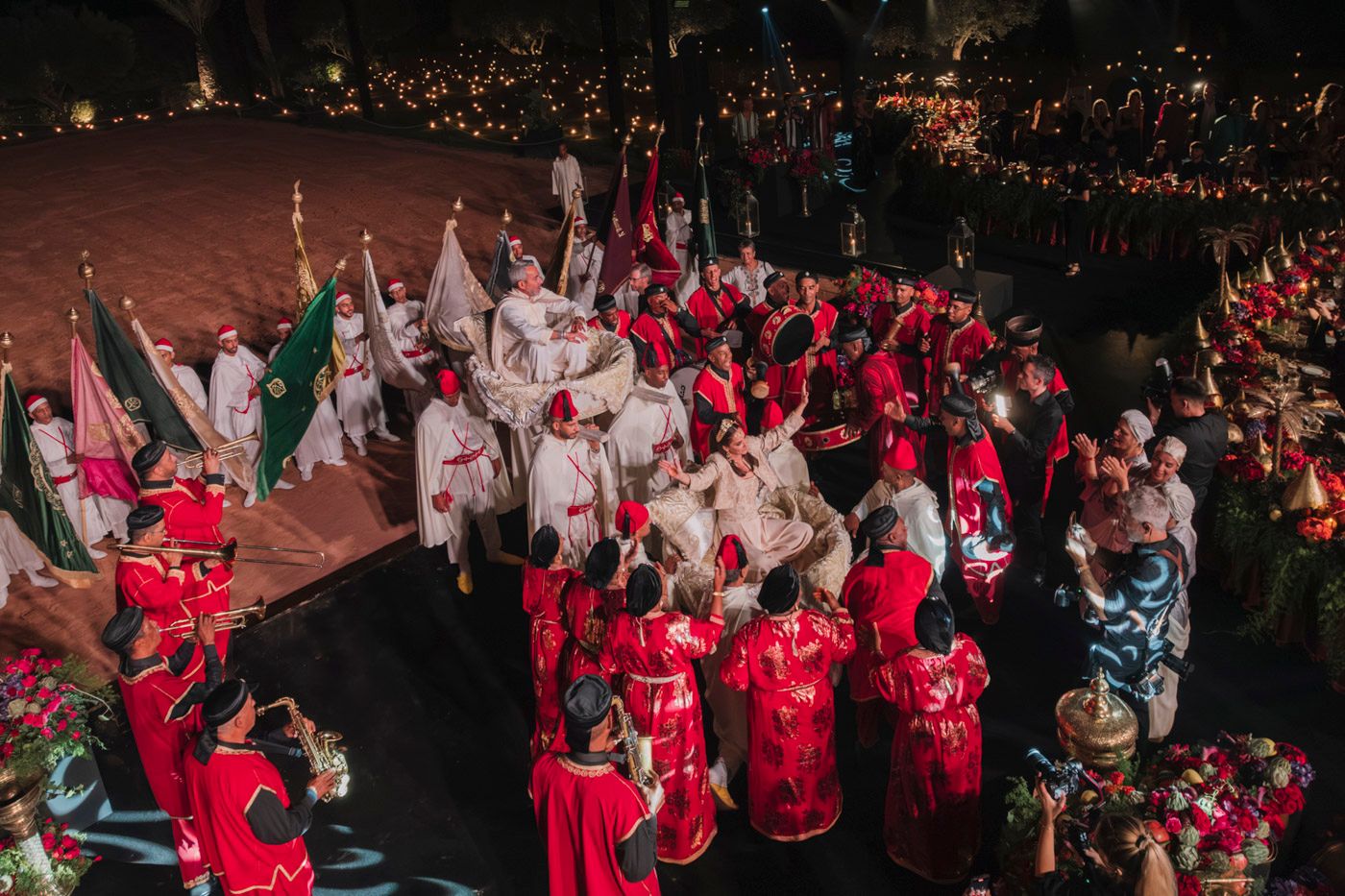 A festive crowd gathered in red and white outfits during a nighttime celebration event.