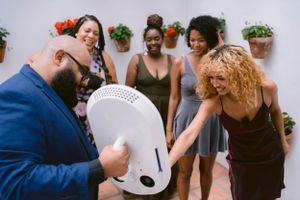Group having fun with the Roamer photo booth, smiling and capturing lively moments together during their event.