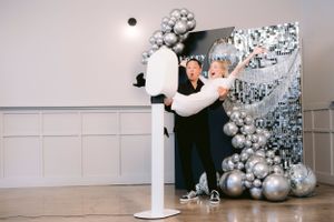 A couple enjoying a fun, playful moment together, posing with smiles and laughter in a joyful and energetic scene.
