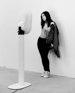Beautiful young woman posing in front of the photo booth, capturing a fun and stylish moment.