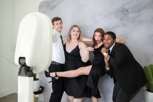 Group of young people having fun in the photo booth, smiling and capturing memorable moments during their event or celebration.