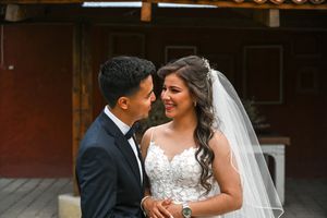 A romantic wedding moment captured with the bride wearing a lace dress and flowing veil.