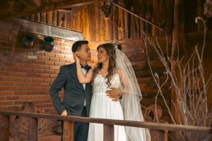 Romantic moment captured in a rustic brick-walled venue with natural lighting.