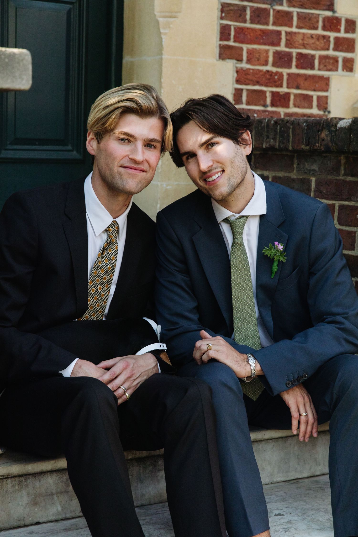Two people in formal attire sit close together on stone steps.