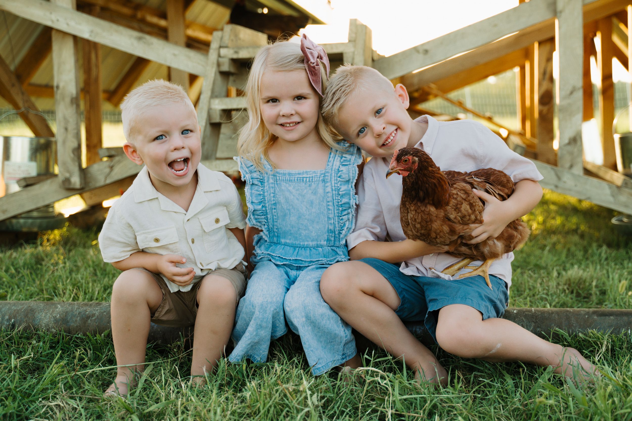 Children sitting together on grass during a casual outdoor family gathering.