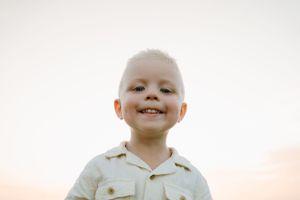 Close-up portrait showing joyful expression during outdoor family photoshoot.