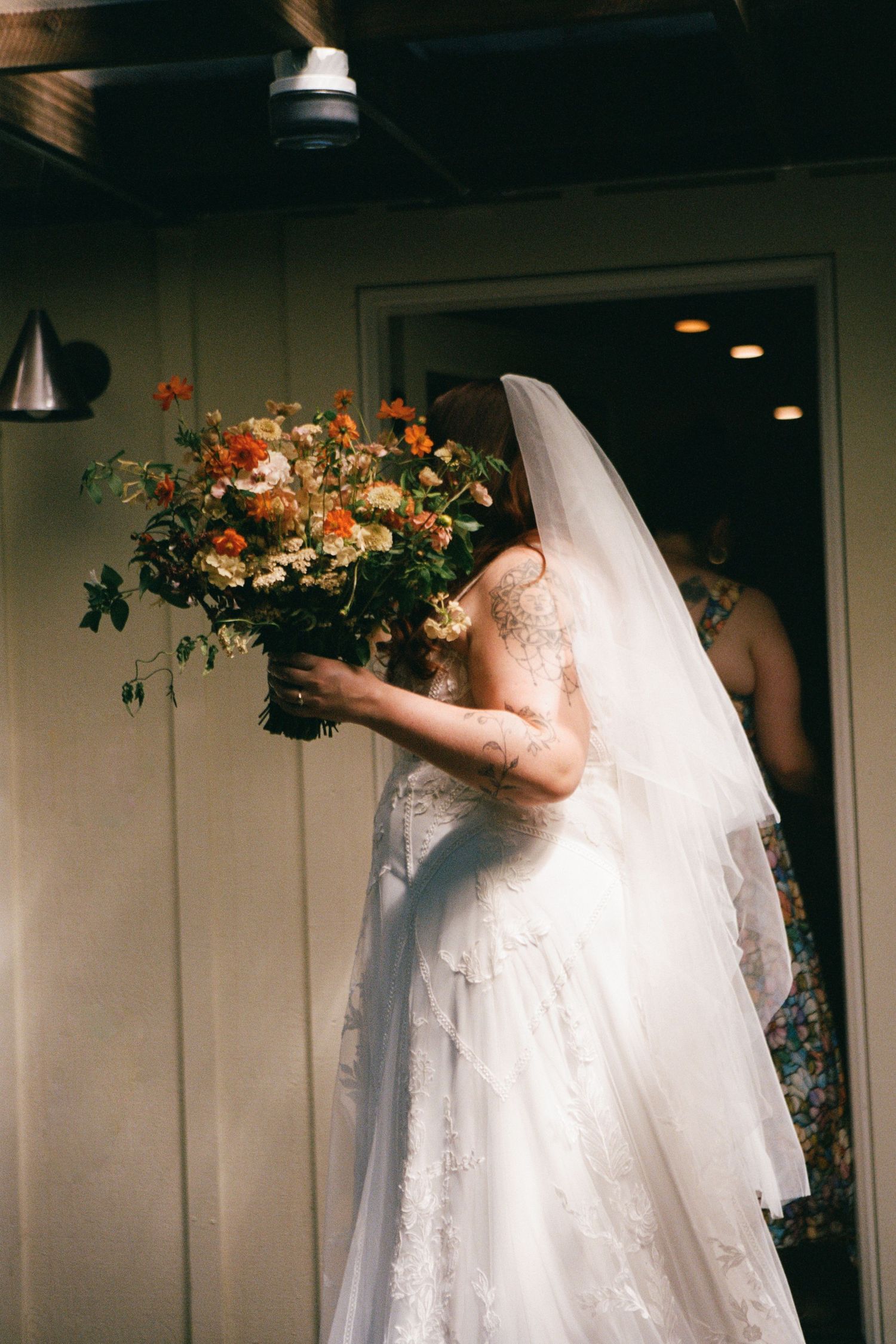 A romantic outdoor photoshoot in a sunlit wooded area with dappled light filtering through the trees.
