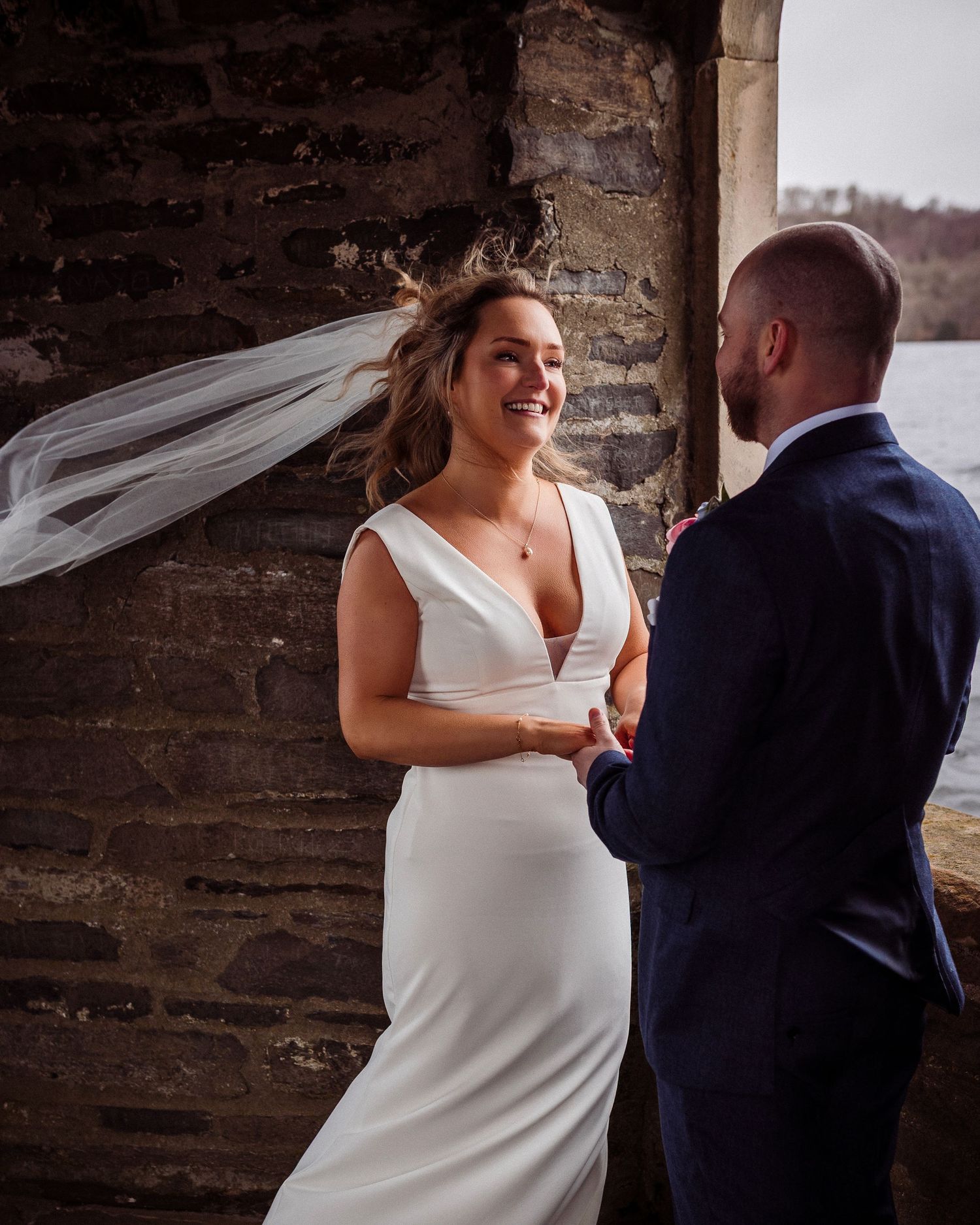 Couple standing together beneath the stone arch at Temple of Heroes, Storrs Hall