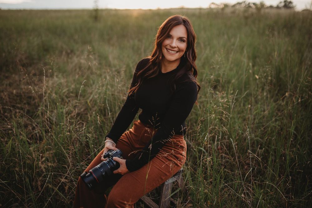 Artistic outdoor photography session in tall grass field during golden hour.