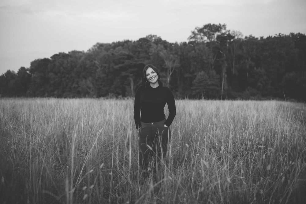 A series of black and white photographs showing a person walking through a tall grass field.