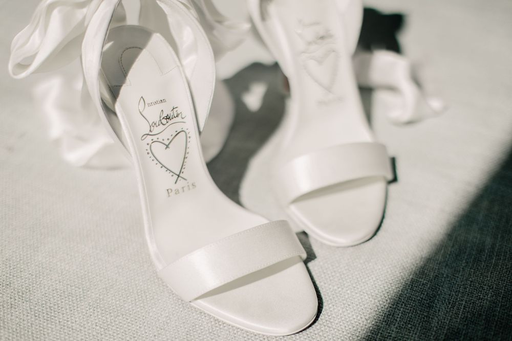 White bridal heels with ribbon ties and heart detail on insole.
