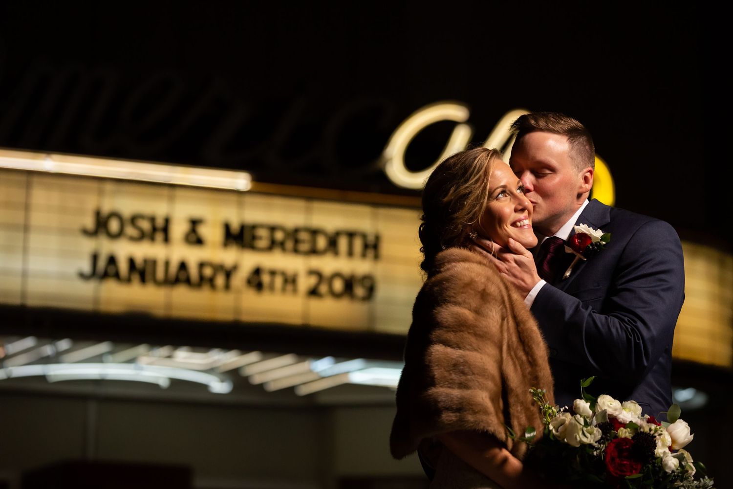 Josh and Meredith share a romantic kiss under a glowing marquee sign on their wedding day, January 4th, 2019.
