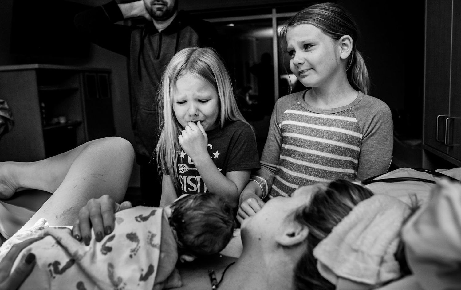 Emotional moment captured in a hospital room during childbirth.