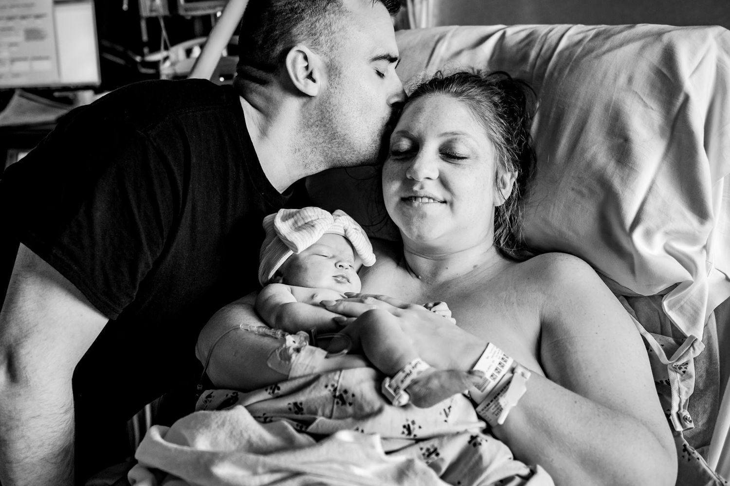 A touching black and white hospital scene shows a tender moment with a newborn baby.