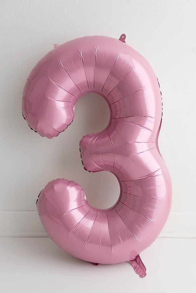 Pink satin number 3 foil balloon against a white background for 3rd birthday photoshoot in Menifee.