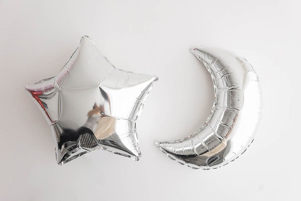Silver star and crescent moon foil balloons on white background for cake smash photoshoot in Menifee.