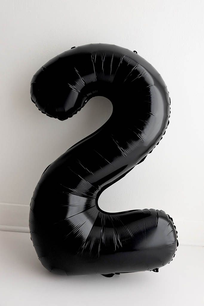 Black shiny number 2 foil balloon against a white background for 2nd birthday photoshoot in Menifee CA.
