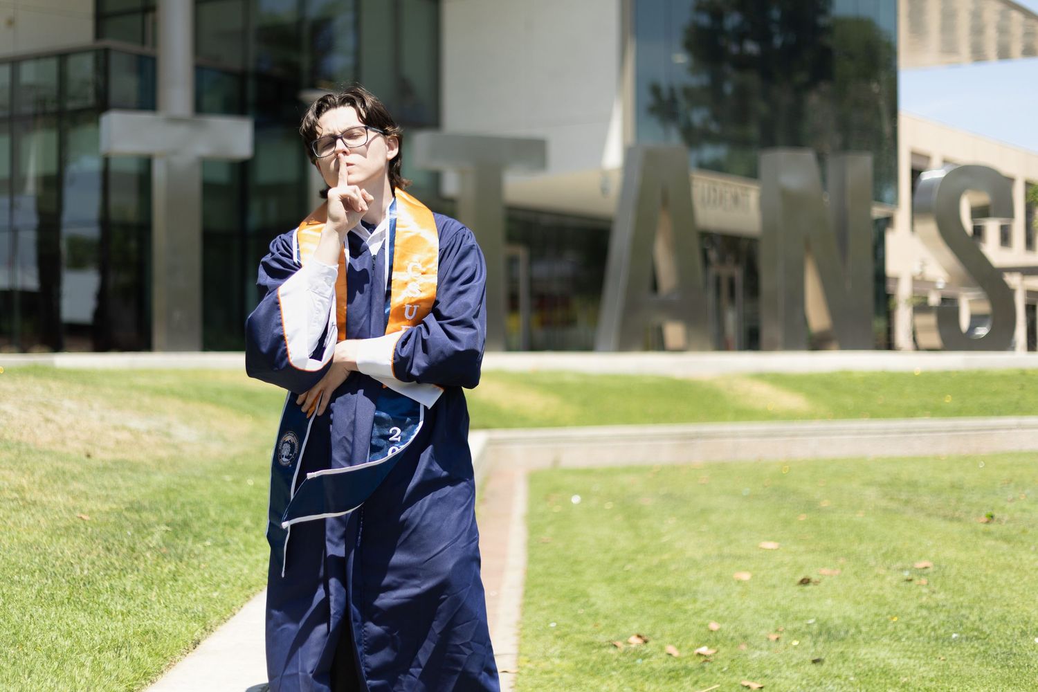 a unique pose for the graduate as the words Titans are in the background. Funny pose to show the personality of the graduate.