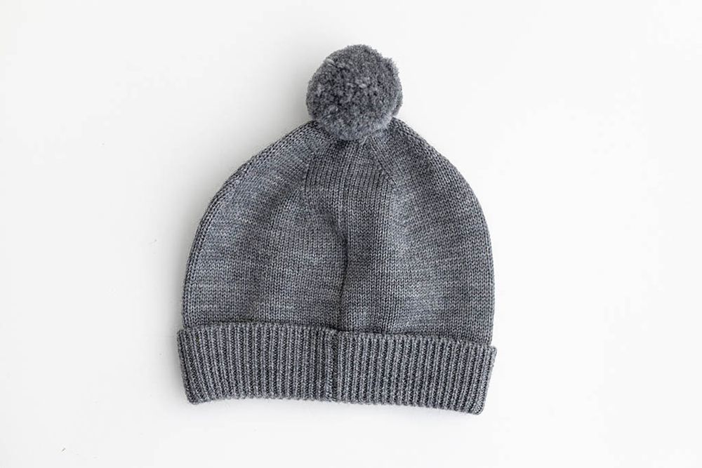 Dark gray knit beanie hat with pom pom for baby photo outfit.