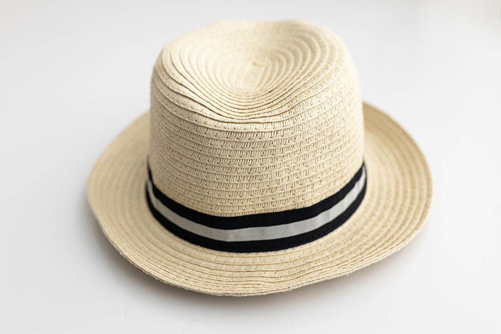Baby boys beige woven straw fedora hat with black and white striped band on white background.
