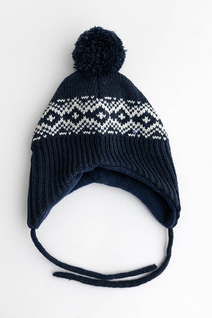 Navy blue Nordic pattern knit baby hat with pompom and ear flap ties.