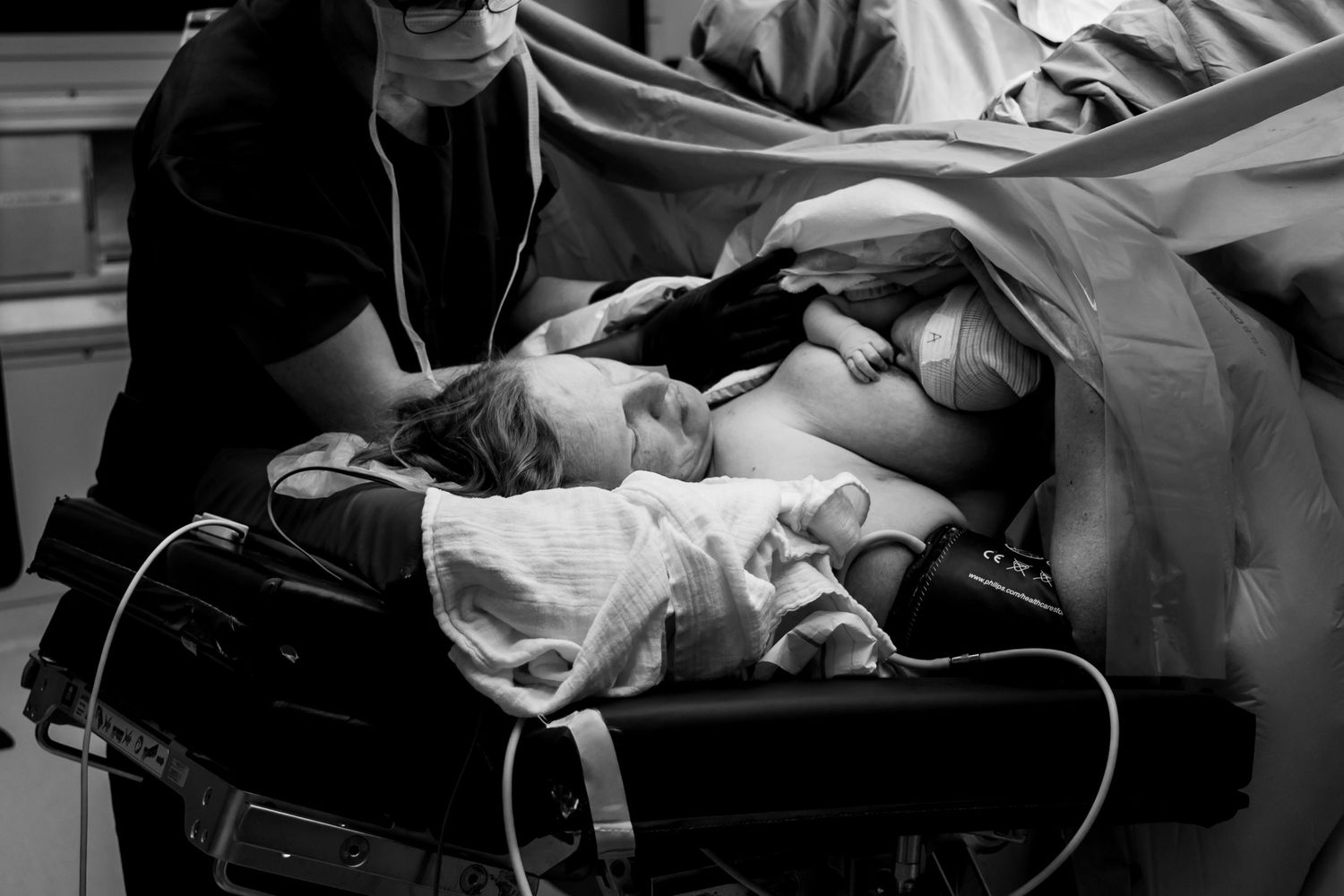 Hier zie je een mama tijdens een keizersnede. Haar kindjes zijn al geboren en een van de baby's ligt bij mama op de borst