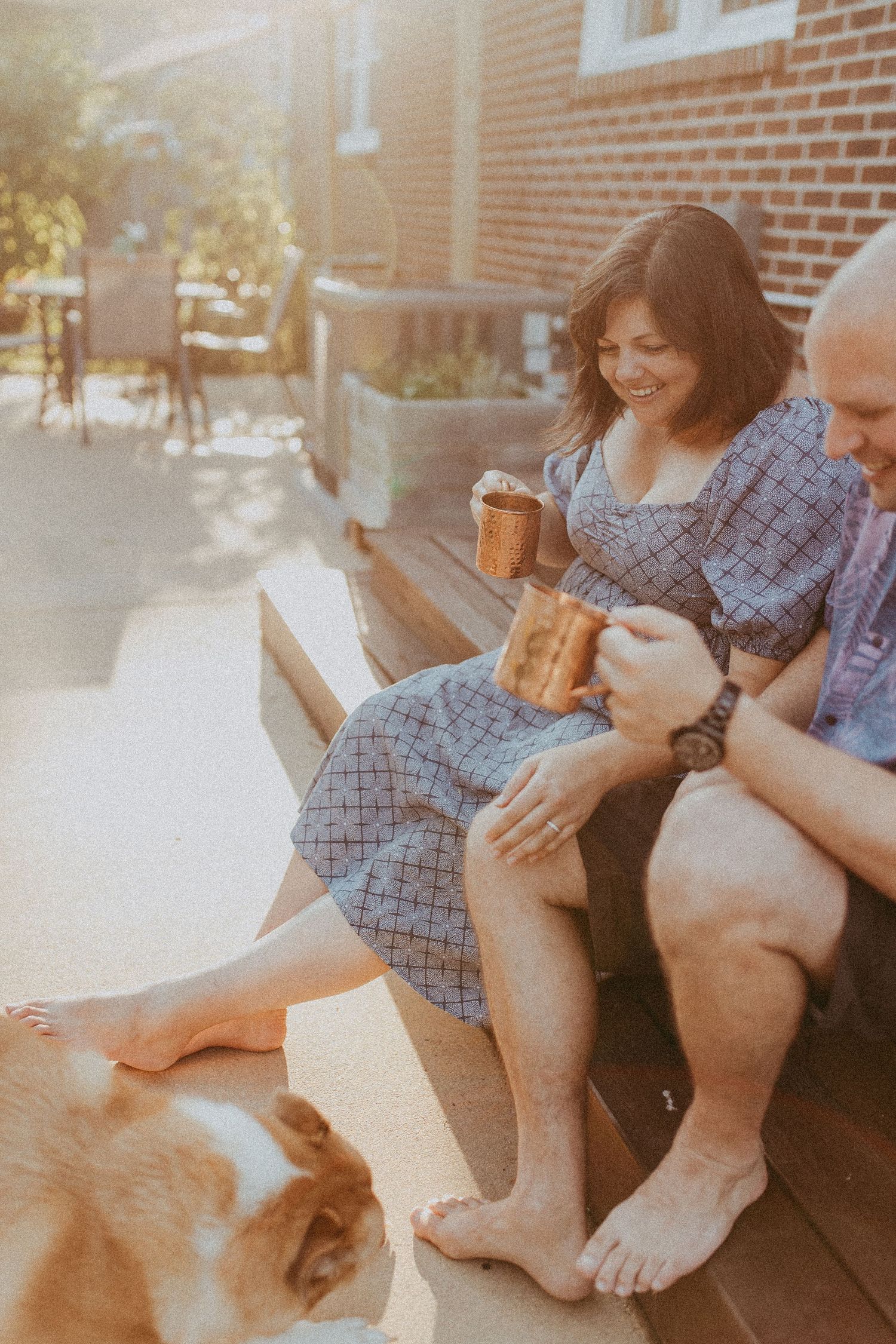 Couple sitting on porch steps sharing drinks with their dog in warm golden sunlight. Whitney Popp, Phoenix Arizona photographer