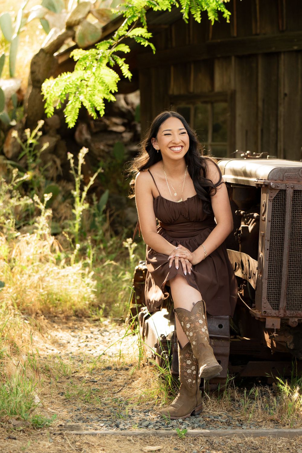 Casual portrait session near rustic wooden barn with vintage decor.