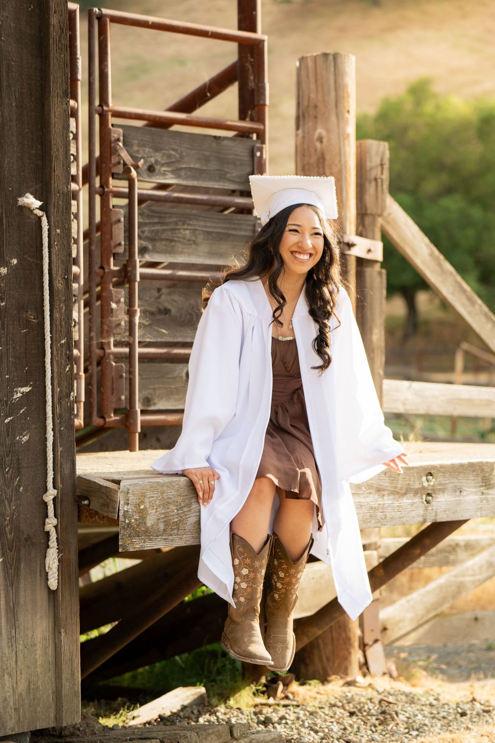 Candid graduation portraits taken at rustic wooden location during golden hour.