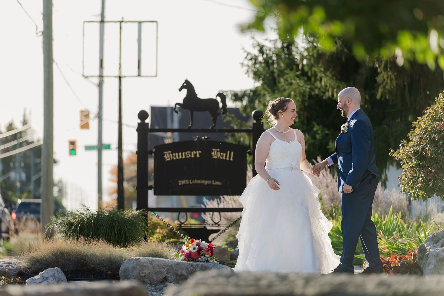 Candid wedding photography of bride and groom standing together outside the front of Hauser Hall for a quiet moment before their reception.