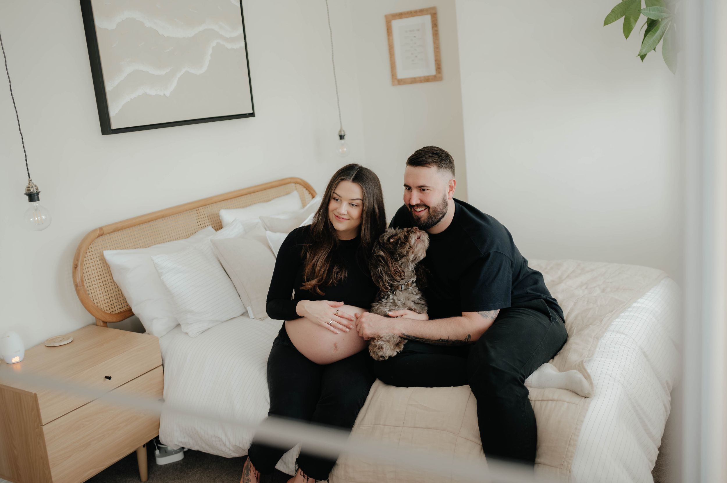 A series of four intimate black and white photos showing couples cuddling together on a cozy white bed.