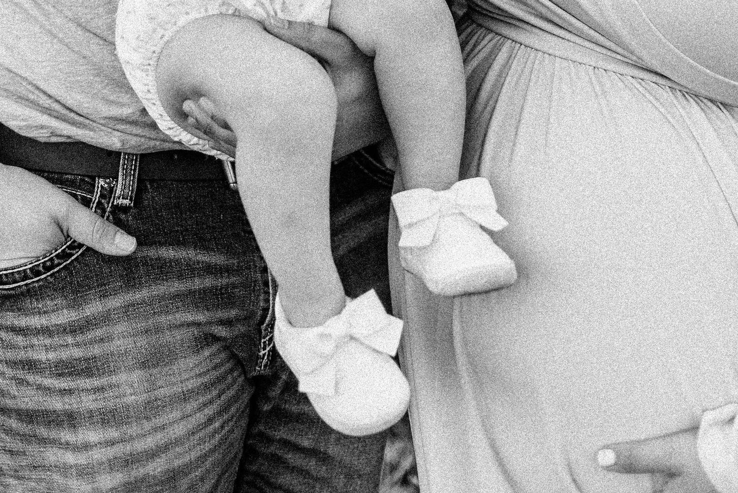 A grainy black and white photo showing someone holding and caring for a small baby.