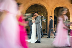 Motion blur captures dancers in flowing dresses spinning across a ballroom floor during a formal dance event.