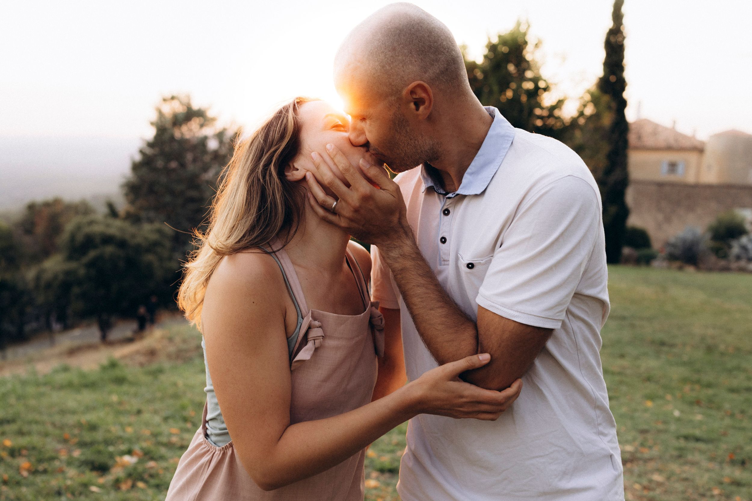 A romantic couple in black jackets share intimate moments against a dramatic stormy sky background.