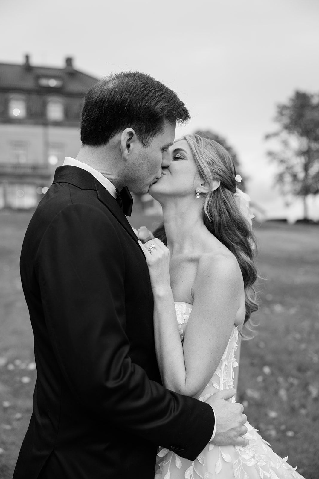 A romantic black and white photo sequence shows a couple sharing a tender kiss outdoors.