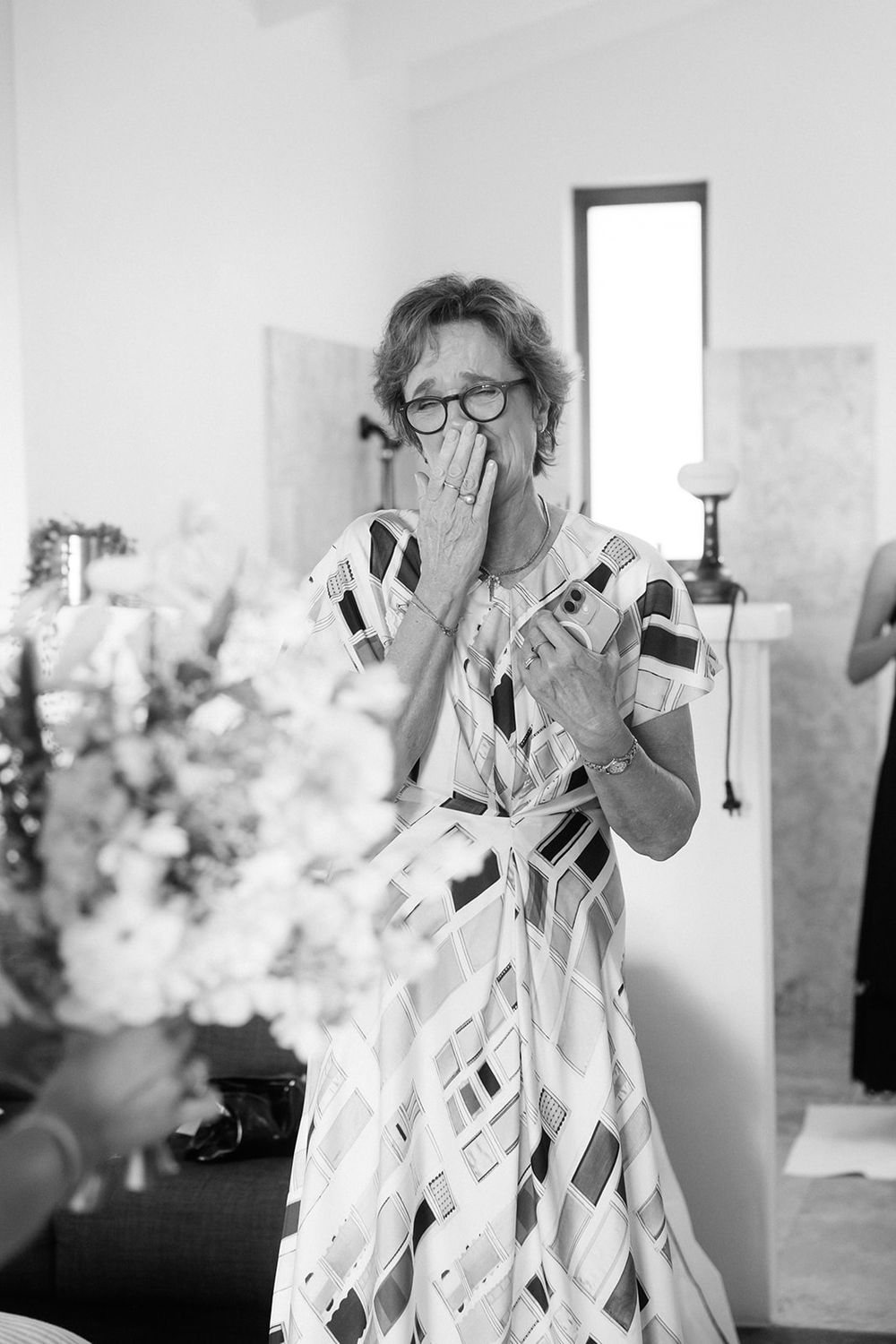 A person wearing a geometric white paper dress performs in an art gallery space.